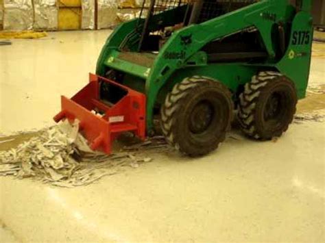 tile removal for a skid steer|Floor tile removal with a skid steer scraper attachment.